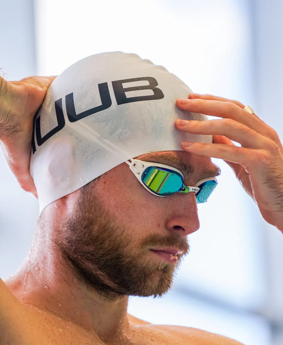 Bright orange HUUB silicone swim cap with smooth, flexible material designed for comfortable swimming and water resistance.